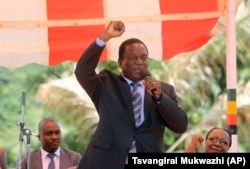 FILE - In this image taken Feb, 10, 2016, Zimbabwean Deputy President Emmerson Mnangagwa greets party supporters at the ZANU-PF headquarters in Harare.