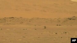 In this image from NASA, NASA's experimental Mars helicopter Ingenuity lands on the surface of Mars Monday, April 19, 2021. (NASA via AP)