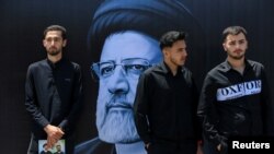 Mourners attend a burial ceremony of the late Iran's President Ebrahim Raisi in Mashhad