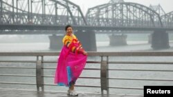 지난 2010년 6월 중국 단둥과 북한 신의주를 잇는 다리를 배경으로 한복을 입은 관광객이 포즈를 취하고 있다.