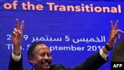 FILE - Sudanese Prime Minister Abdalla Hamdok flashes the victory gesture during a press conference unveiling the first Cabinet since veteran leader Omar al-Bashir's overthrow, in Khartoum, Sept. 5, 2019. 