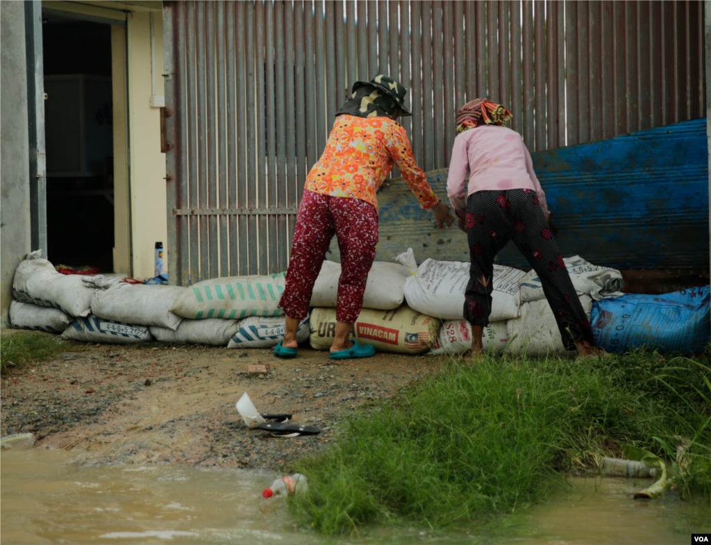Two women put stack sandbags to keep rising waters from flooding their house in Spean Tmor commune, Dangkoa district, Phnom Penh, Cambodia, on Oct. 14, 2020. (Malis Tum/VOA Khmer)