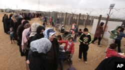 Syrian women wait in line to receive winter aid as UN General Assembly President Mogens Lykketoft visits Zaatari refugee camp in Mafraq, Jordan, Jan. 20, 2016. Jordan says the most recent census counted 1.265 million Syrians in the kingdom, or twice the number of registered Syrian refugees.