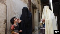 FILE - A Pakistani health worker administers the polio vaccine to a child during a vaccination campaign in Bannu on June 25, 2014. 