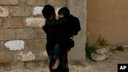 Dečak nosi mlađeg dečaka u kampu Al-Hol u pokrajini Hasakeh u Siriji (Foto: AP/Maya Alleruzzo)