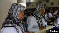FILE - A migrant worker heading for Middle East countries holds her passport documents at an immigration office in Tangerang, Indonesia's Banten province, in June 2011.