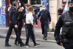 A woman reacts after several people were injured near the former offices of the French satirical magazine 'Charlie Hebdo' following an attack by a man wielding a knife in Paris, Sept. 25, 2020.