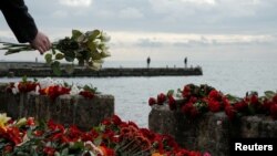 A person lays flowers in memory of passengers and crew members of Russian military Tu-154, which crashed into the Black Sea on its way to Syria on Sunday, at an embankment in the Black Sea resort city of Sochi, Russia, December 26, 2016. 