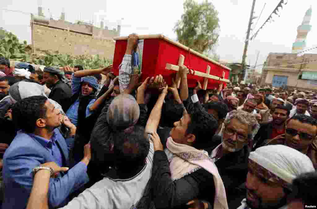Mourners carry the coffin of Bashar Arhab, a victim of one of Friday's suicide bombings at mosques, in Sanaa, March 23, 2015.