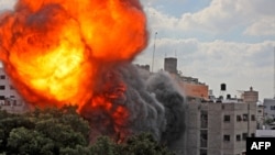 A ball of fire engulfs the Al-Walid building which was destroyed in an Israeli airstrike on Gaza city early in the morning, May 13, 2021.