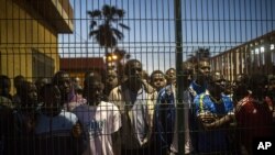 Des migrants au Centre d’accueil temporaire de migrants devant les treillis séparant le Marco et l’Espagne à Melilla, 28 mi 2014. 