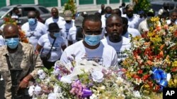 លោក Pierre Gary Bernadotte សមាជិកគណបក្ស​នយោបាយ PHTK របស់​ប្រធានាធិបតី​ដែល​ត្រូវបានគេសម្លាប់ យកផ្កា​ទៅ​ដាក់​កន្លែង​មួយ​នៅ​ខាងក្រៅ​វិមាន​ប្រធានាធិបតី ដើម្បីរំឭក​វិញ្ញាណក្ខន្ធ​អតីត​ប្រធានាធិបតីលោក Jovenel Moise នៅ​រដ្ឋធានី​ព័រអូប្រាំង ប្រទេសហៃទី កាលពីថ្ងៃពុធទី១៤ ខែកក្កដា ឆ្នាំ២០២១។