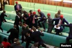 Ugandan opposition lawmakers fight with plain-clothes security personnel in the parliament while protesting a proposed age limit amendment bill debate to change the constitution for the extension of the president's rule, in Kampala, Sept. 27, 2017.