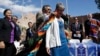 Navajo Nation President Ben Shelly (L) puts a blanket on the shoulders of U.S. Interior Secretary Sally Jewell after a ceremonial signing of a record multi-million-dollar settlement, in Window Rock, Arizona, at the Navajo Nation, Sept. 26, 2014.