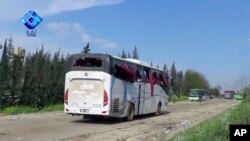 This frame grab from video provided by the Thiqa News Agency, shows buses damaged by a blast at the Rashideen area, a rebel-controlled district outside Aleppo city, April. 15, 2017.