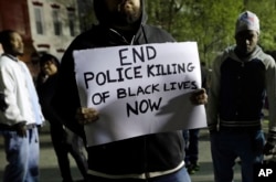 FILE - A protester outside the Baltimore Police Department's Western District police station in Baltimore, April 23, 2015.