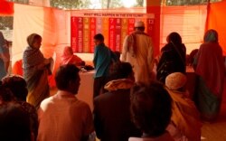 Rohingya refugees and residents of host community in Cox’s Bazar wait in line for the free eyecare clinic Onesight at Kutupalong Government Primary School, Feb. 13, 2020. (Hai Do/VOA)