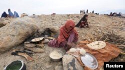 ​ស្រ្តី​ជនជាតិ​អាហ្វហ្គានីស្ថាន​ដែល​ភៀសខ្លួន​ពី​តំបន់​ជម្លោះកំពុង​ធ្វើនំប៉័ង​នៅ​ក្នុង​ជំរំ​ក្នុង​ស្រុង Khogyani
​ខេត្ត Nangarhar ប្រទេស​អាហ្វហ្គានីស្ថានកាលពី​ថ្ងៃទី​២៧ ខែ​វិច្ឆិកា ឆ្នាំ ២០១៧។