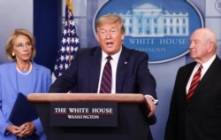 U.S. President Donald Trump addresses the daily coronavirus response briefing as Education Secretary Betsy DeVos and Agriculture Secretary Sonny Perdue listen at the White House in Washington, U.S., March 27, 2020. REUTERS/Jonathan Ernst