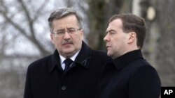 Poland's President Bronislaw Komorowski (l) and Russia's President Dmitry Medvedev during a ceremony marking the one-year anniversary of the Polish presidential plane crash at the crash site near Smolensk, western Russia, April 11, 2011