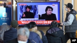 People watch a TV screen showing images of South Korean director Bong Joon Ho during a news program at the Seoul Railway Station in Seoul, South Korea, Monday, Feb. 10, 2020.