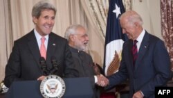 Menlu AS John Kerry berbicara pada acara di Deplu AS sementara Wapres AS Joe Biden berjabat tangan dengan PM India Narendra Modi, di Washington, DC, 30 September 2014.