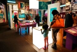 FILE - Visitors look at information presented at the National Museum of African American Music, Jan. 30, 2021, in Nashville, Tenn.
