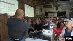 លោក​យ៉ារី លីវ៉ាន់​ បង្ហាញ​អ្នក​ចូលរួម​ពី​ការ​សូន​ក្អមឆ្នាំង។ (ពិន ស៊ីសុវណ្ណ/VOA)