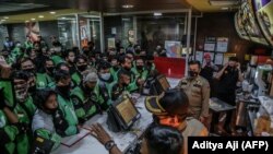 Pengemudi pengiriman makanan mengantre di gerai McDonald's di Bogor pada 9 Juni 2021. Mereka membeli paket meal BTS, menyebabkan lebih dari selusin gerai McDonald's tutup sementara karena ketakutan perebakan virus corona. (Foto: AFP/Aditya Aji)