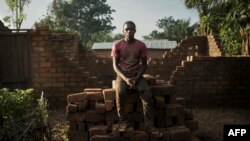 Ismael, un ancien combattant anti-Balaka de 17 ans, prend une pause lors de la reconstruction d'une ferme dans le centre de Bambari, le 4 octobre 2017.