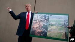 FILE - President Donald Trump talks with reporters as he gets a briefing on border wall prototypes, in San Diego, California, March 13, 2018.