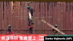 在塞尔维亚贝尔格莱德以北50公里的塞尔维亚北部城镇兹雷尼亚宁附近，越南工人在一家中国汽车轮胎工厂建筑工地工作。（2021年11月18日）