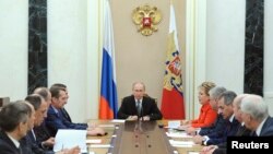 Russian President Vladimir Putin (C) chairs a meeting with members of the Security Council at the Kremlin in Moscow, Mar. 6, 2015. Russia is seen as using propaganda and money to, as one analyst put it, "divide and split Europe." 