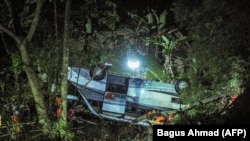 Tim penyelamat mengevakuasi korban kecelakaan bus yang jatuh ke jurang di Kecamatan Wado, di Sumedang, Jawa Barat, yang merenggut 27 nyawa,10 Maret 2021. (Foto: Ilustrasi/AFP/Bagus Ahmad)