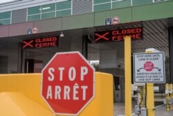 FILE - Two closed Canadian border checkpoints are seen at the US-Canada border crossing at the Thousand Islands Bridge in Lansdowne, Canada, March 19, 2020.