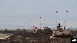 Tentara Turki dan Irak duduk di atas kendaraan lapis baja milik militer Turki selama latihan di Silopi, dekat gerbang perbatasan Habur dengan Irak, tenggara Turki, 26 September 2017.