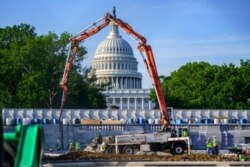 FILE - A concrete pump frames the Capitol Dome during renovations and repairs to Lower Senate Park on Capitol Hill, May 18, 2021. President Joe Biden hopes to pass a massive national infrastructure plan.