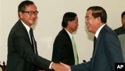 Cambodian Prime Minister Hun Sen shakes hands with opposition leader Sam Rainsy before a meeting at the National Assembly.