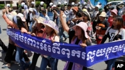 Cambodian activists shout slogans during a march toward the National Assembly, in Phnom Penh, Cambodia, Thursday, May 29, 2014. Some 300 activists on Thursday delivered petitions to the National Assembly and Anti-Corruption Unit headquarters to demand the government to stop giving land concession to private companies. The banner reads " Absolutely against the corruption in the society." (AP Photo/Heng Sinith)