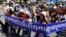 Cambodian activists shout slogans during a march toward the National Assembly, in Phnom Penh, Cambodia, Thursday, May 29, 2014. Some 300 activists on Thursday delivered petitions to the National Assembly and Anti-Corruption Unit headquarters to demand the government to stop giving land concession to private companies. The banner reads " Absolutely against the corruption in the society." (AP Photo/Heng Sinith)
