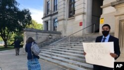 Lawyer Daniel Brown holds a poster calling on Georgia lawmakers to pass a state hate crimes law on June 18, 2020 in Atlanta, Georgia. 