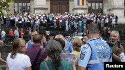 FILE - Romanian magistrates hold a silent protest in support of an independent judiciary in Bucharest, Romania, Sept.16, 2018.