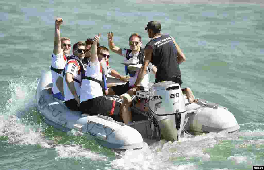Germany&#39;s national soccer team members wave as they are transported to the sailing ship &#39;Pangaea&#39; near Santo Andre village, near Porto Seguro, Brazil, June 10, 2014.