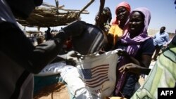 South Sudanese refugees collect aid food at a "Refugee Waiting Centre" in Al-Eligat area along the border in Sudan's White Nile state, Feb. 27, 2017.