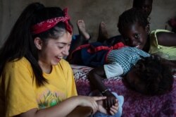 Teresa Topete, a rising junior at Lich-Wilmerding High School in San Francisco, walks with her host family in the village of Guedj Martin, Senegal. (Annika Hammerschlag, for VOA)