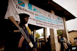 FILE - A Congolese soldier stands guard outside a military tribunal in Baraka, Democratic Republic of Congo, Feb. 17, 2011. Eleven soldiers were charged with crimes against humanity over an instance of mass rape and looting in the eastern town of Fizi in January 2011.