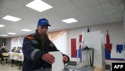 Raia wa Russia anapiga kura katika uchaguzi wa urais. March 15, 2024. (Photo by STRINGER / AFP)