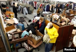 FILE - People look for clothes at the Capuchin Soup Kitchen service center in Detroit, where hundreds of people receive food and supplies every day.