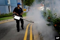 A pest control worker fumigates drains at a local housing development where Zika infections were reported in Singapore, Sept. 1, 2016.