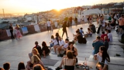 People watch the sun set from a viewpoint overlooking the Tagus river in Lisbon, Oct. 8, 2021. Portugal has scrapped many of its remaining COVID-19 restrictions, after becoming the world leader in the vaccination rollout.